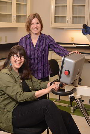 СƬƵ Associate Professor Angela Ridgel (standing) works with a Parkinson’s patient on a specially designed treatment bike.