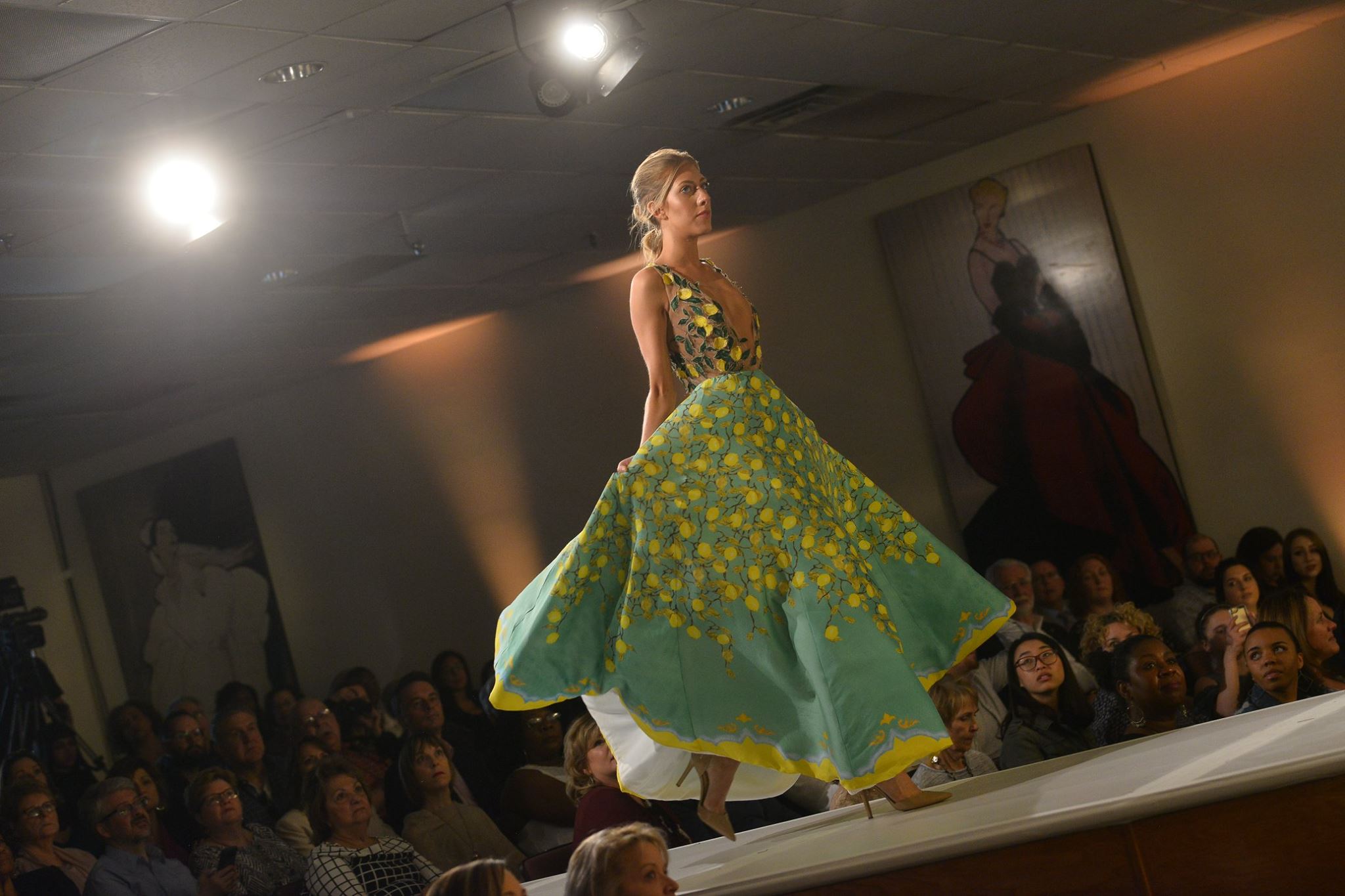 Model on runway sporting green and yellow gown during 2018 Fashion Show