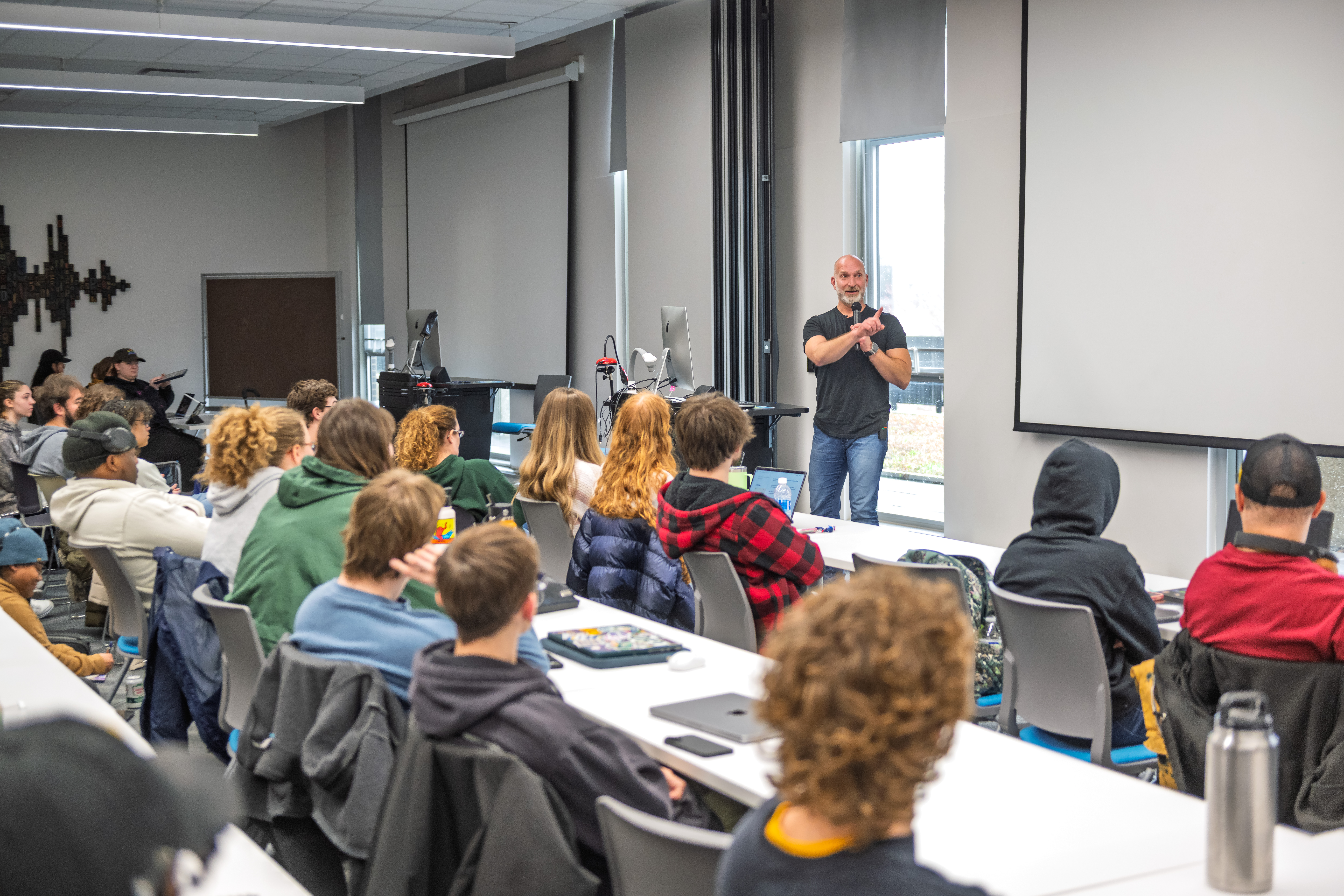 Marcus Lehto speaking to a full classroom of students in a university lecture hall.