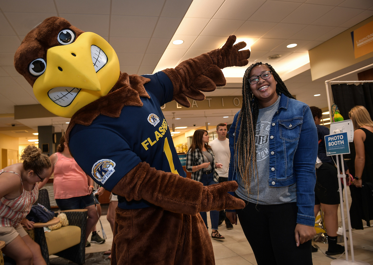 Flash poses for a picture with a student.