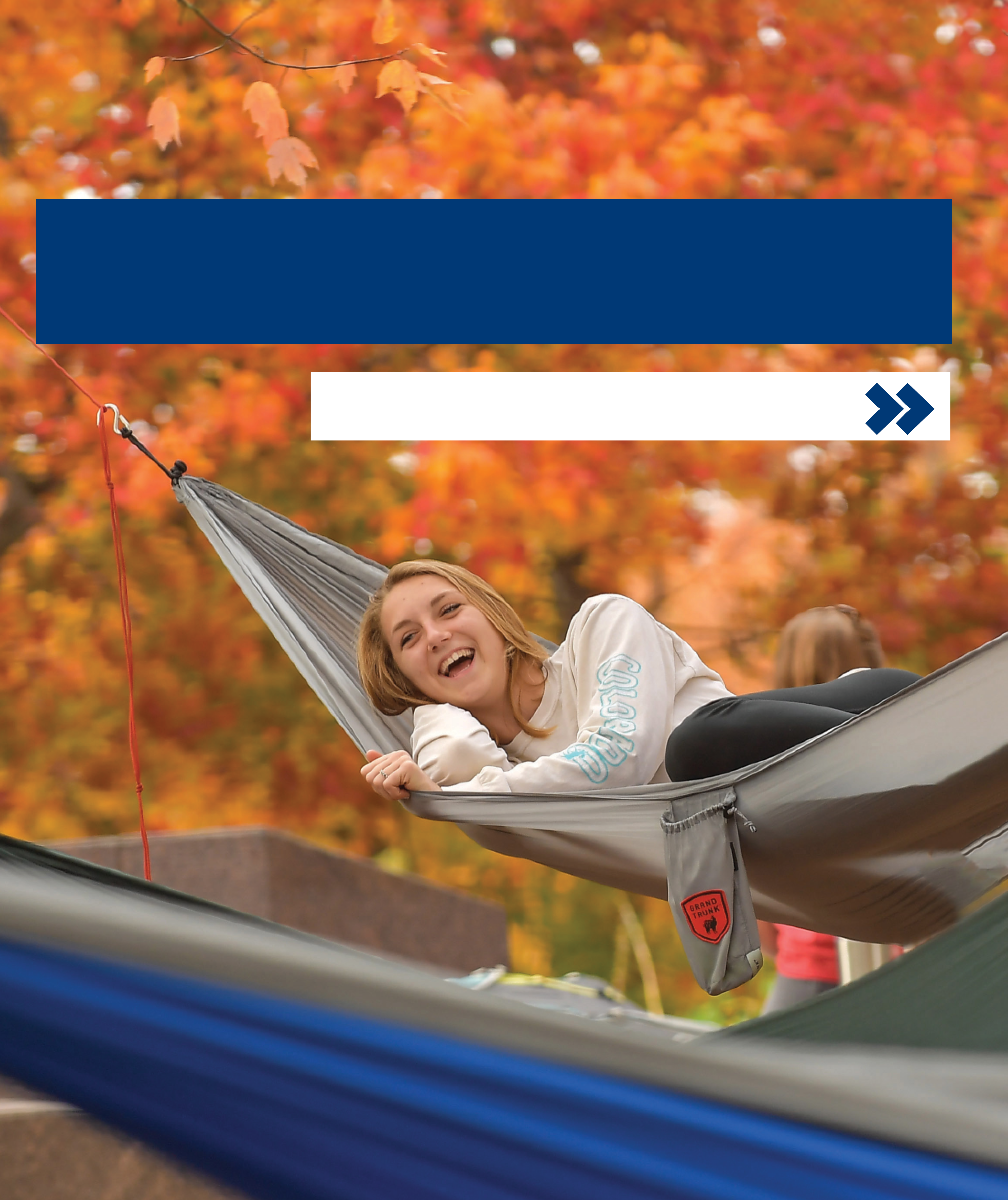 Kent State student in a hammock, surrounded by fall leaves.