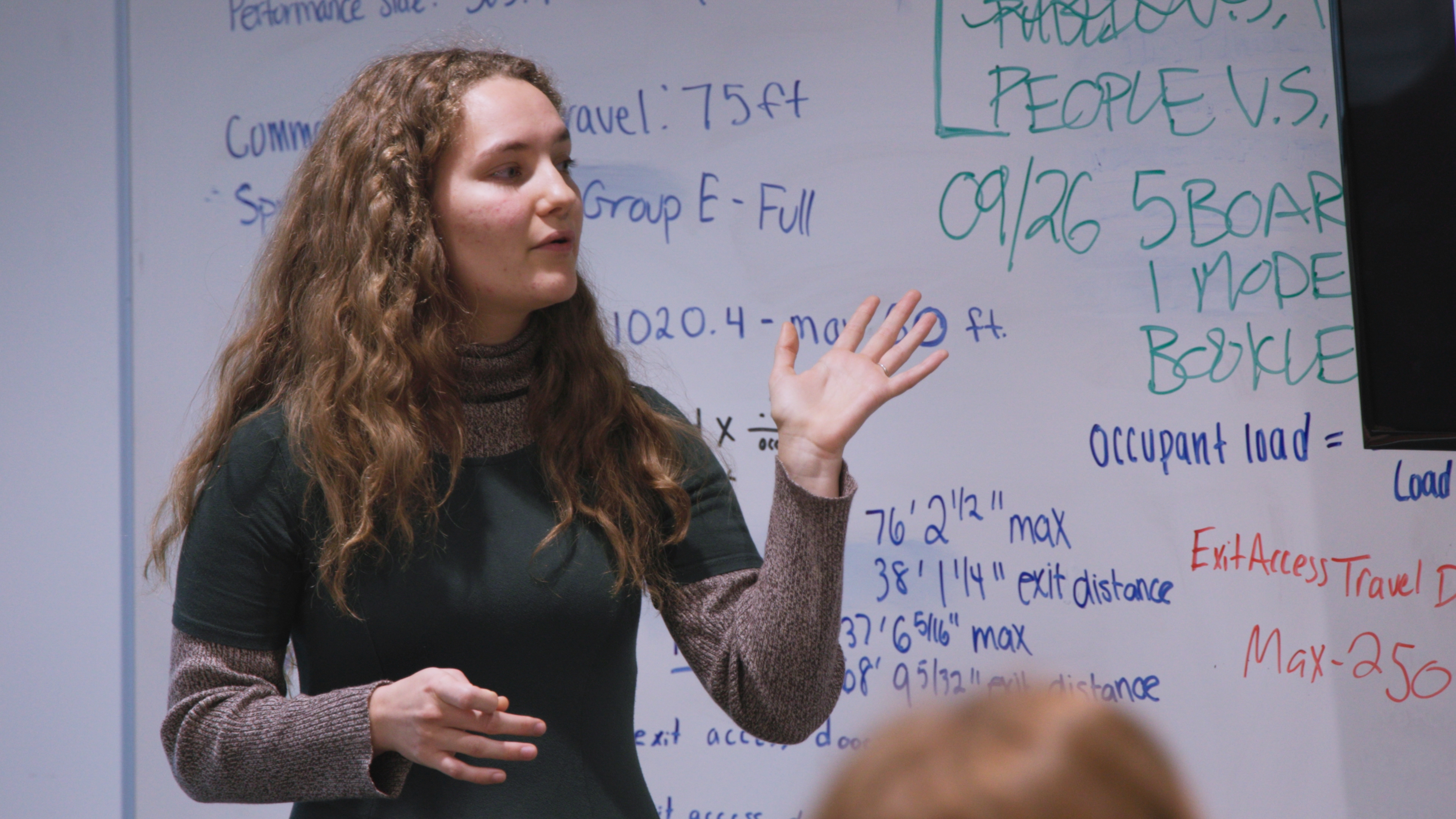 Student speaking in front of white board