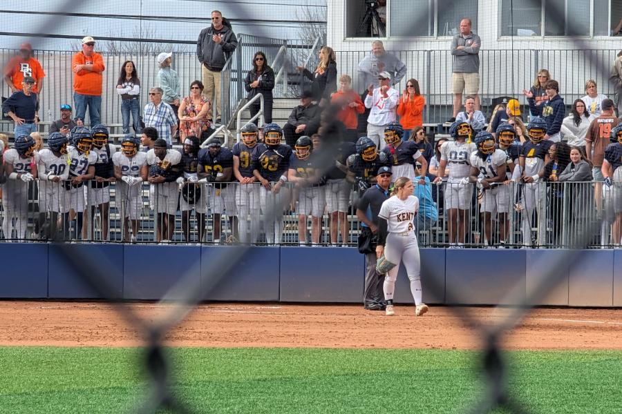 Football team supporting softball team.