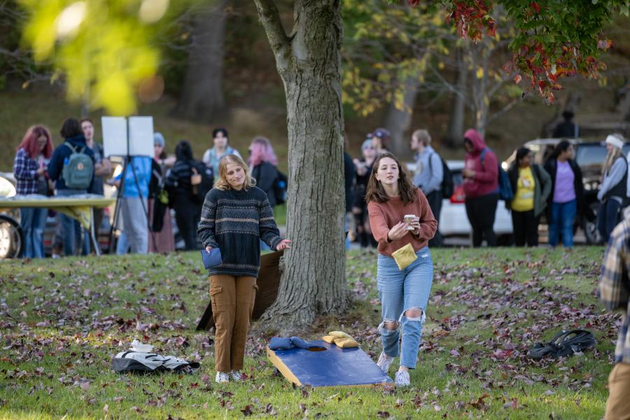 Two students playing cornhole during a fall festival at Âé¶¹¹û¶³.