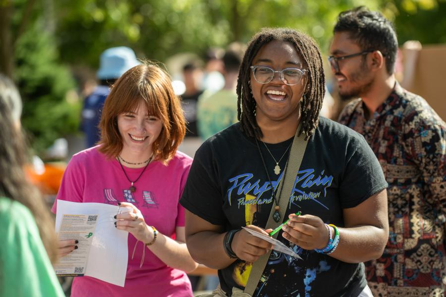 Two students smiling while standing outside at Kent State’s Black Squirrel Festival.