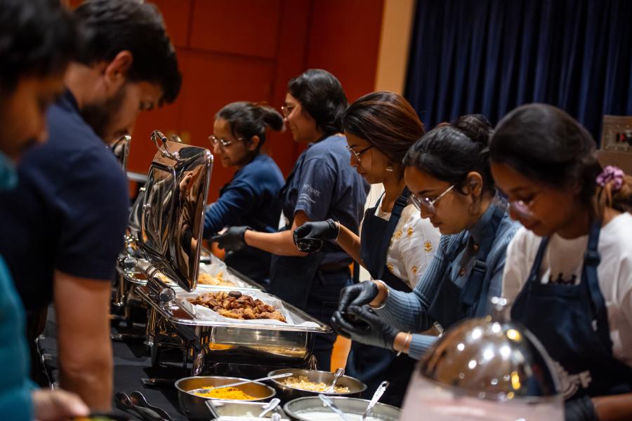 Students from different countries serve food to guests during the International Cook-Off at 51.