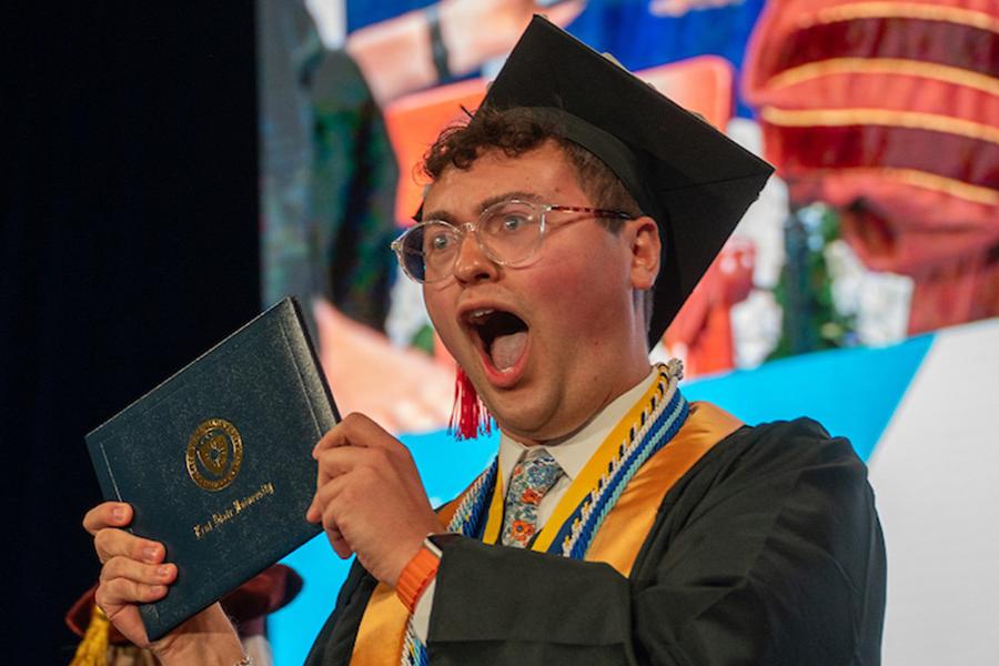 A new 5X���� graduate celebrates after receiving his diploma during the spring 2025 commencement ceremony. (Photo credit: Bob Christy, 5X����)