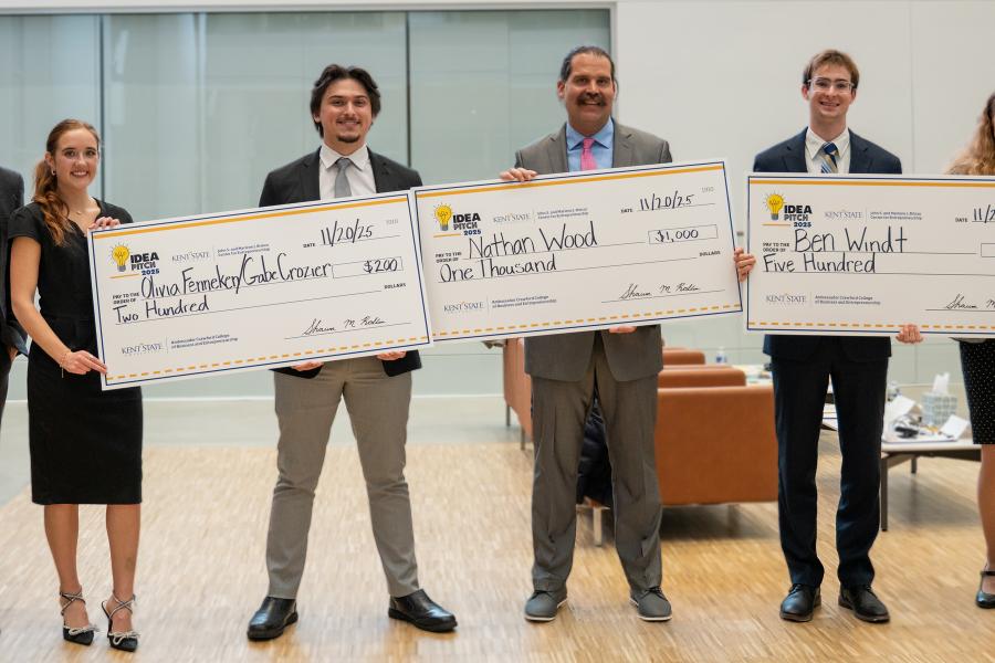 winnners of the 2025 idea pitch, posing with their advisors and large checks. 