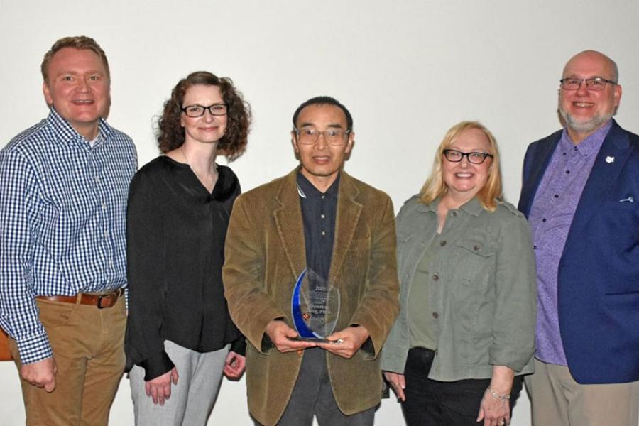 Qunxing Ding (center) was presented with the OER Faculty Champion Award by the selection committee (from left) Paul Campbell, Anita Slack and Cindy Kristo and University Libraries Dean Ken Burhanna (far right)
