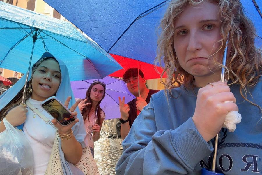 Students stand under their umbrellas on a rainy day in Rome, Italy.