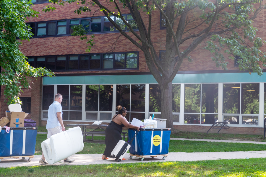 Several individuals help a student move into Fletcher Hall 