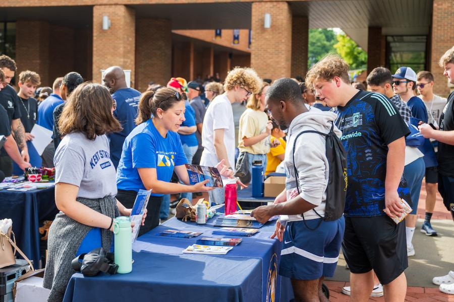 Students talk with a group tabling at an event on campus.