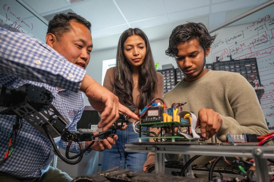 A professor with Kent State's Department of Computer Science works with students on a research project A professor with Kent State's Department of Computer Science works with students on a research project