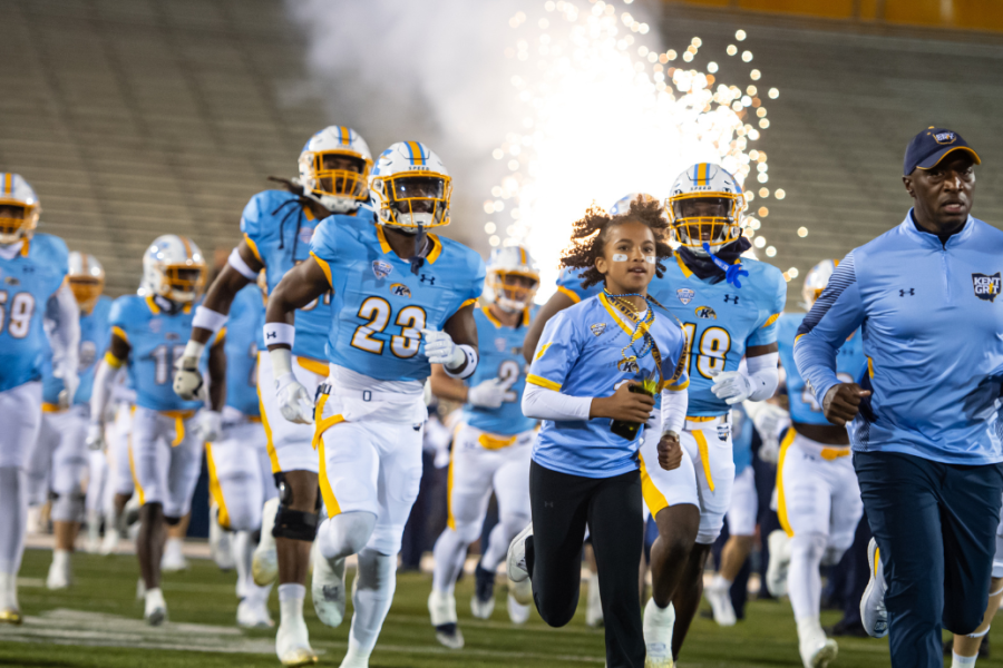 Kent football players run out onto the field.