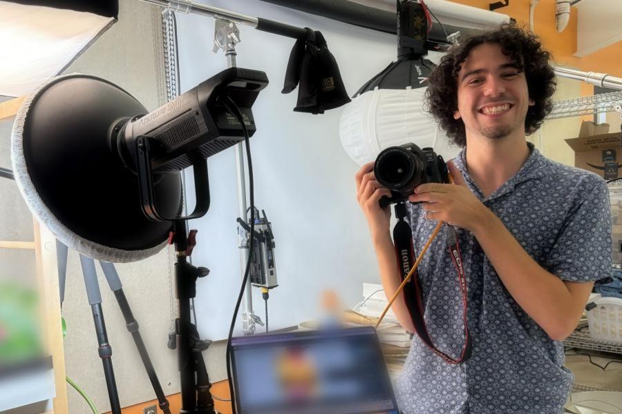Alex Miller taking photos at a photoshoot during his summer internship.