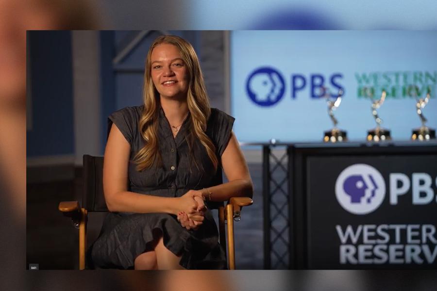 Alumna Sophia Gillespie sitting next to a PBS Western Reserve sign