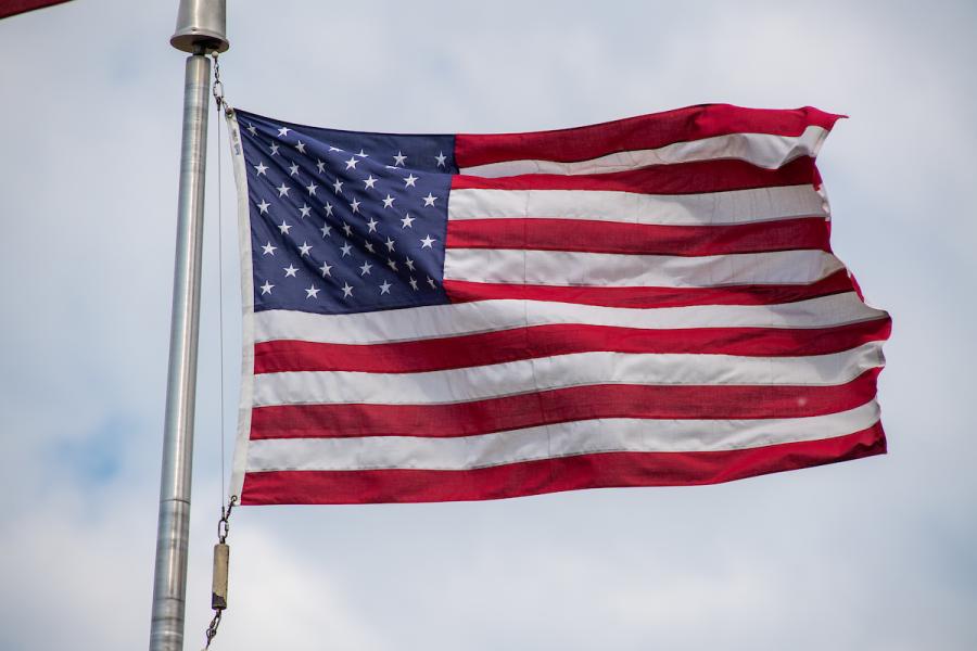 An American flag flies from a flagpole.