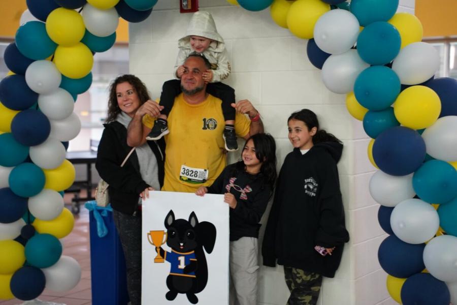 Family posing with black squirrel mascot
