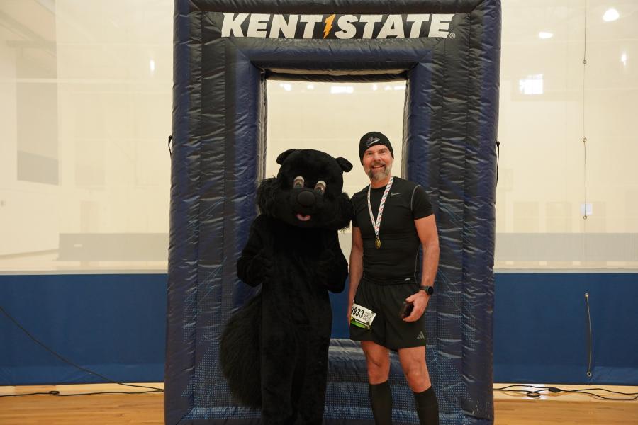 Man posing with black squirrel mascot