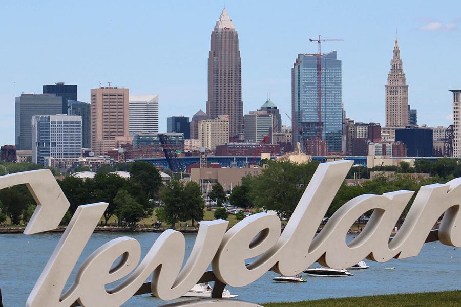 A sign that reads "Cleveland" is shown in the foreground with the city of Cleveland, Ohio, appearing in the background. (Photo credit: Derek Galperin, Kent State University)