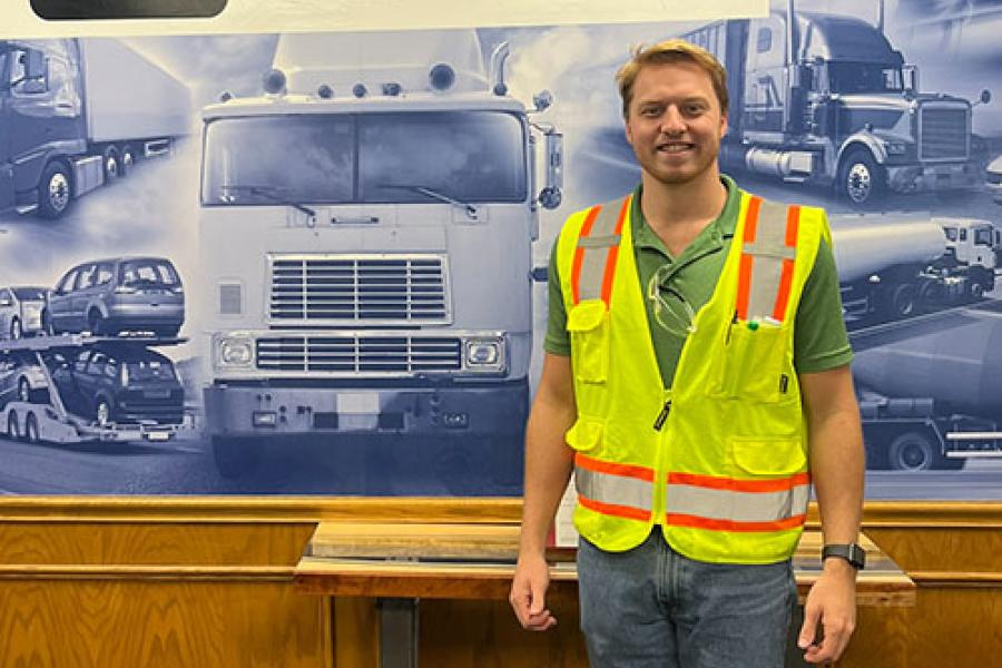 Cooper Flora wearing a safety vest standing in the lobby of Howmet Aerospace