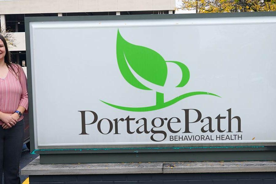 ϲ nursing faculty member Dr. James Tudhope (far right) and his research team members Dr. Andrea Warner Stidham (far left) and Andrea Nelson (center), stand next to the Portage Path Behavioral Health sign.