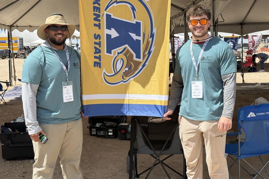 Stuart standing with another student in front of ����ɫ��ҹ flag.