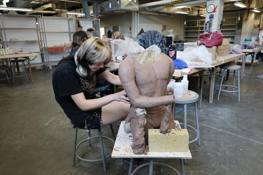 Artist sculpts a sculpture with clay