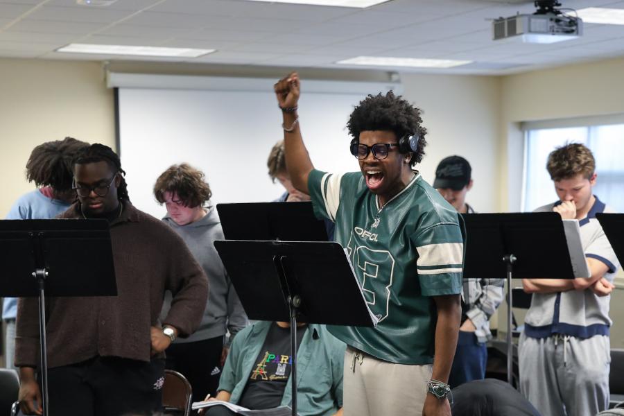 A class of musical theatre students sing along to scores of music