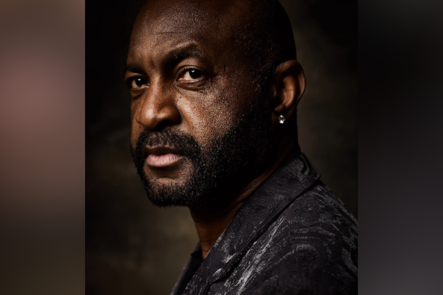 Close-up portrait of Lewis Wiliams wearing dark jacket, looking over his shoulder