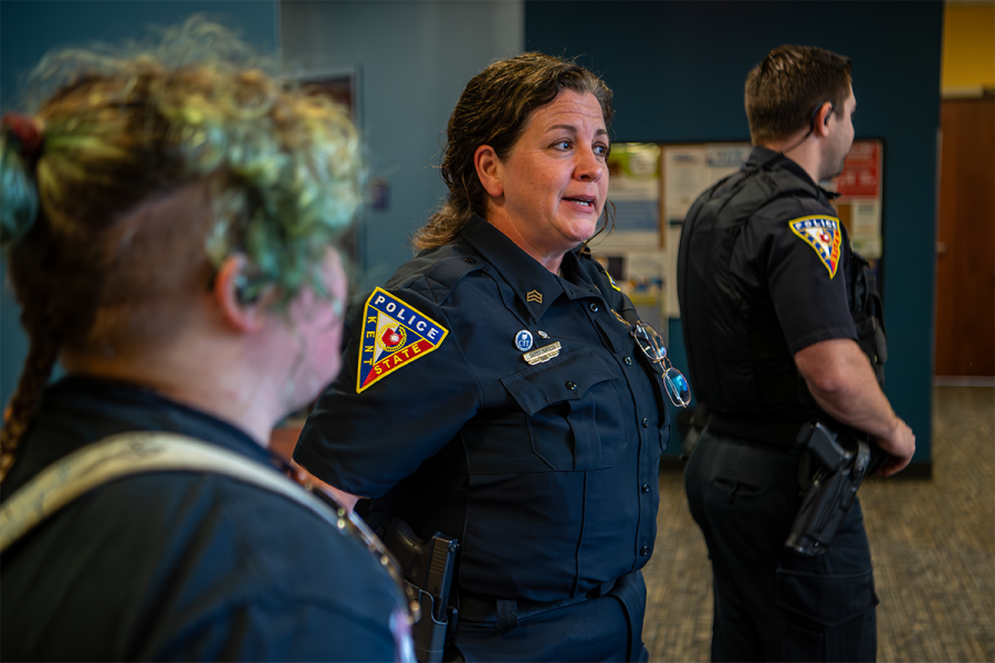 A police officer explains something to two others in training.