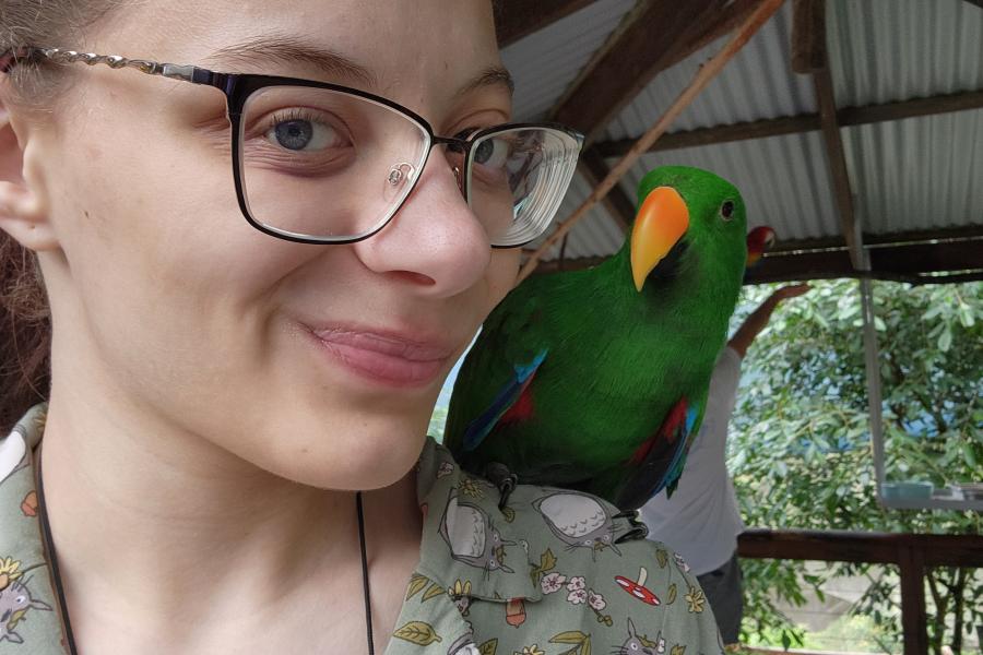 Honors student Maddison Evans poses with a bird during study abroad trip.
