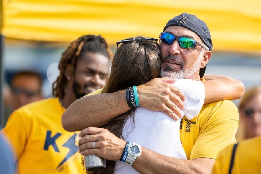 Parent hugging a student at a KSU football game