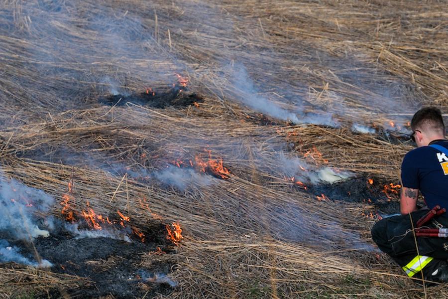 A city of Kent firefighter lights the prairie grass during the annual controlled burning of the prairie. (Photo credit: Bob Christy)