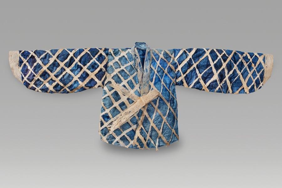 Garment laid out with arms to side; dark blue, light blue colors with a white criss cross pattern. 
