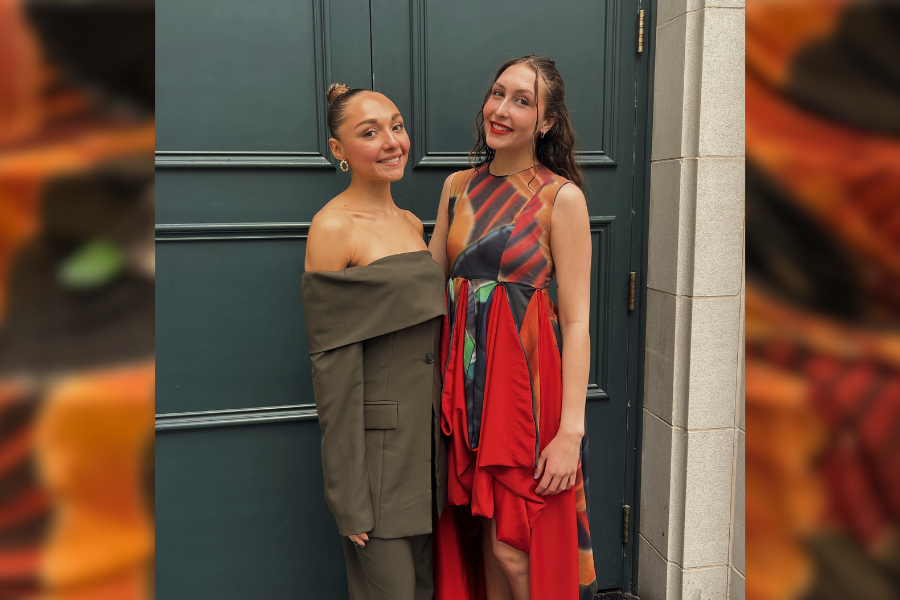 photo of two women posing in front of a door