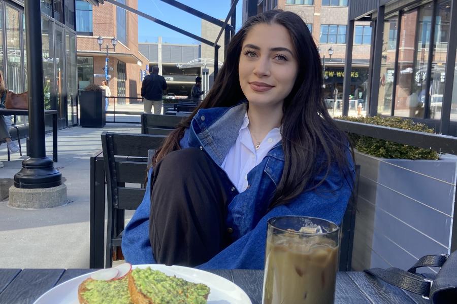 Honors Student Sophia Daher sitting at a table enjoying a meal.