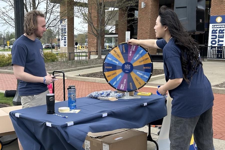 A student spins a prize wheel at a table during Thank-A-Giver Day for Flashes Give Back Week