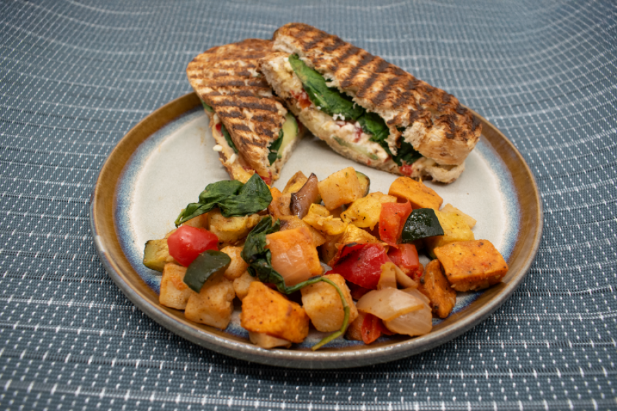 Plate of a panini sandwich and a side of hashbrowns and vegetables from Commerce Café