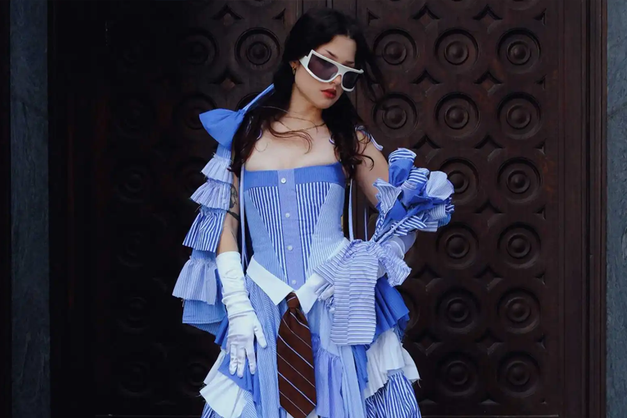 A model wears a blue-and-white reconstructed dress designed by �鶹��ѡ School of Fashion alumna Madeline Mehler, featuring striped shirting, ruffled sleeves and a necktie detail.