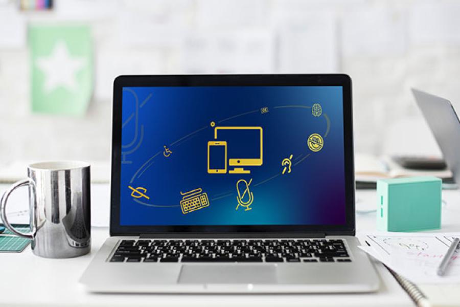 Computer on a desk with coffee mug and notebooks