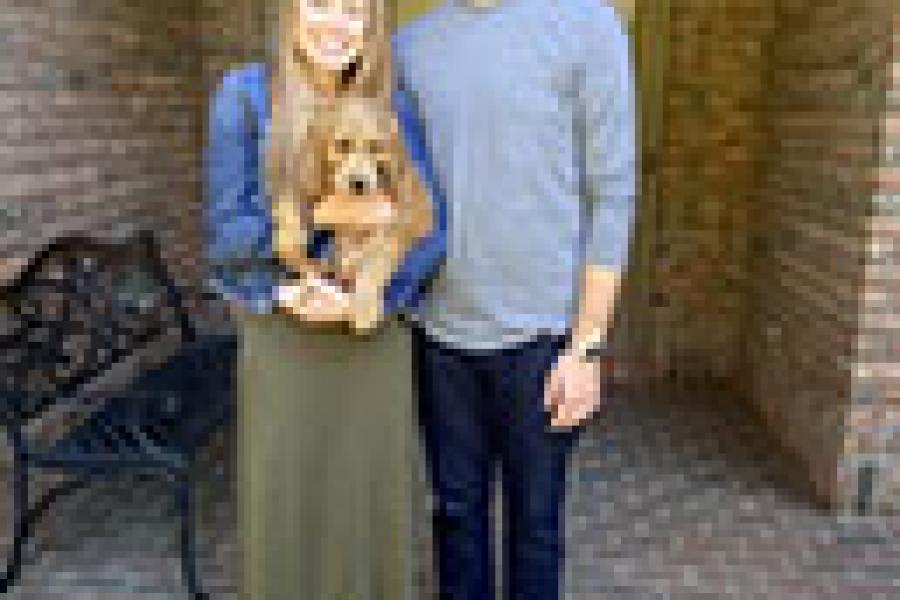Adam and Amanda, holding their dog, posed for the camera