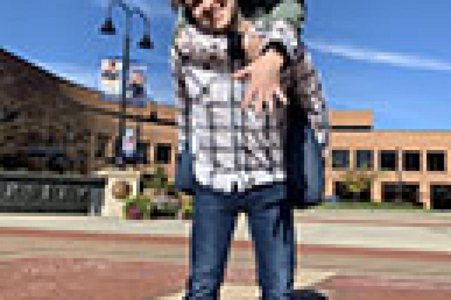 Casey and Kile, newly engaged, standing on the K in Risman plaza