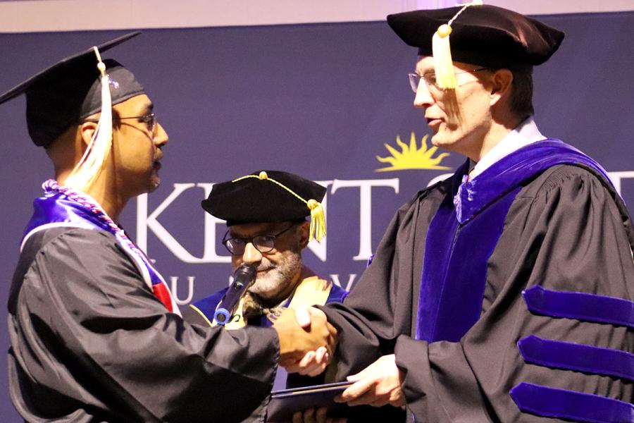 Dean Bill Ayres shakes the hand of a graduating student at commencement