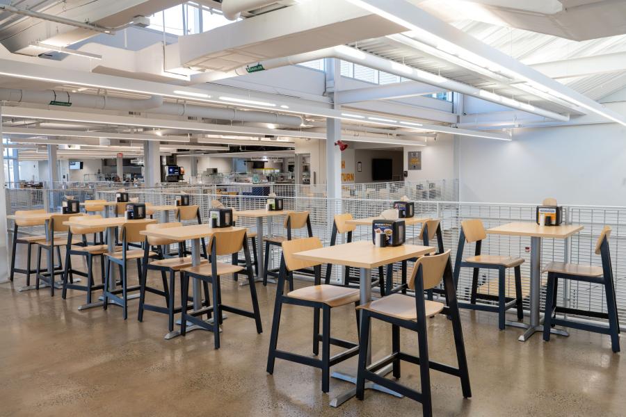 A different seating area within DI Dining, featuring two rows of high-top tables. The Dish Return entrance is visible in the background.