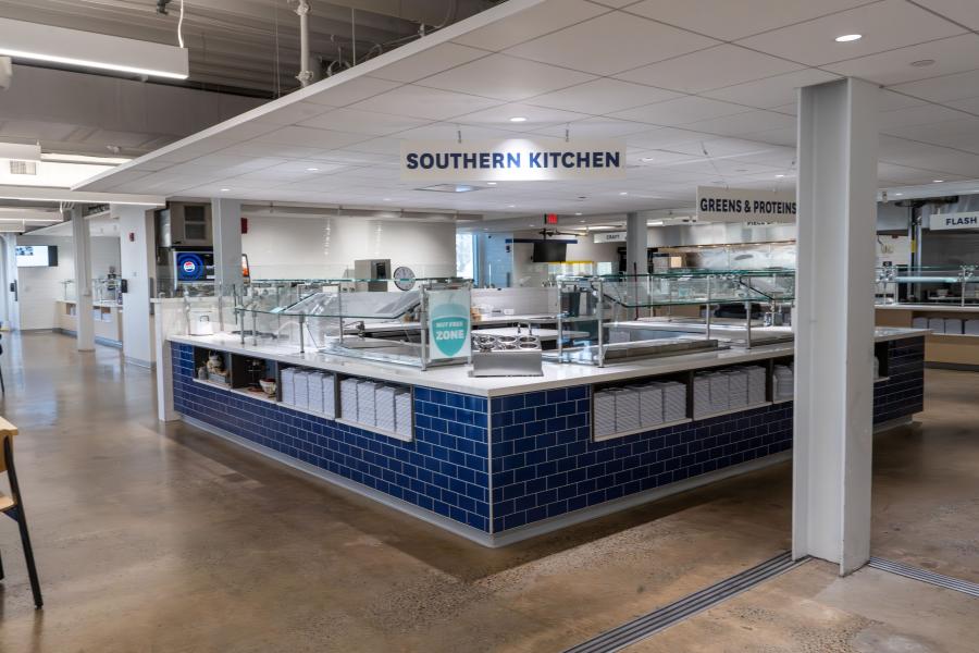 View of DI Dining's "Southern Kitchen" area, featuring prep counters and stacks of plates