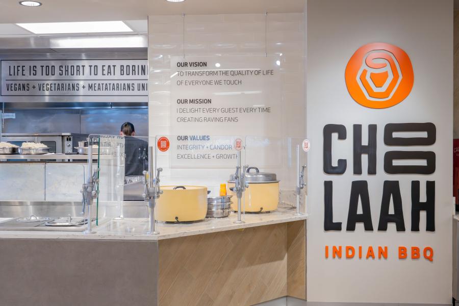 Close up of the Choolaah Indian BBQ area in Eastway, including a side wall with the Choolaah logo, and a prep counter with large pots