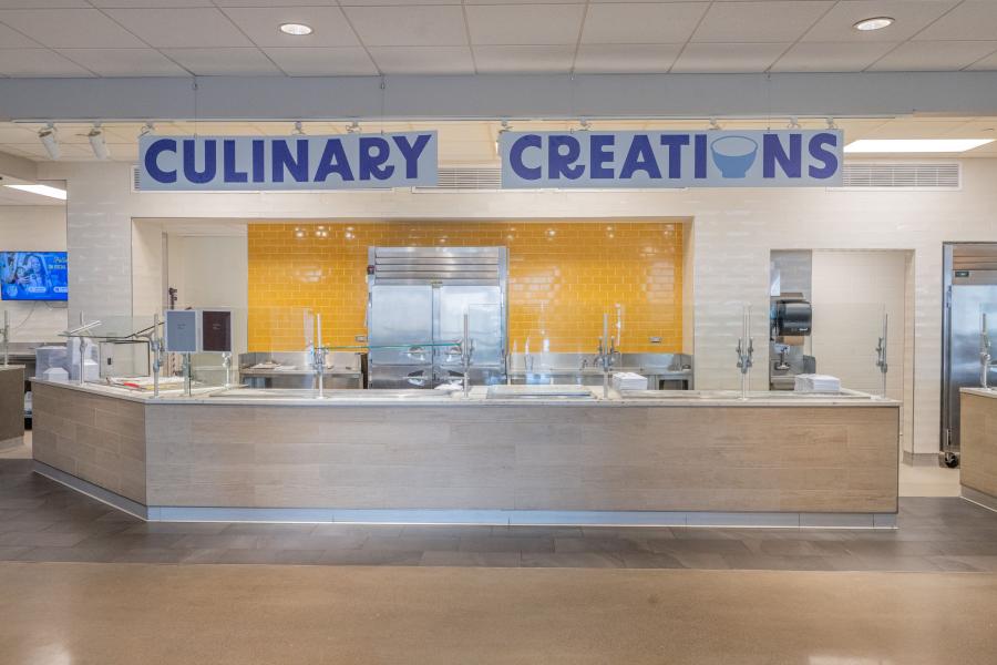 View of Eastway's "Culinary Creations" area, including a prep counter, storage cooler, and stacked plates