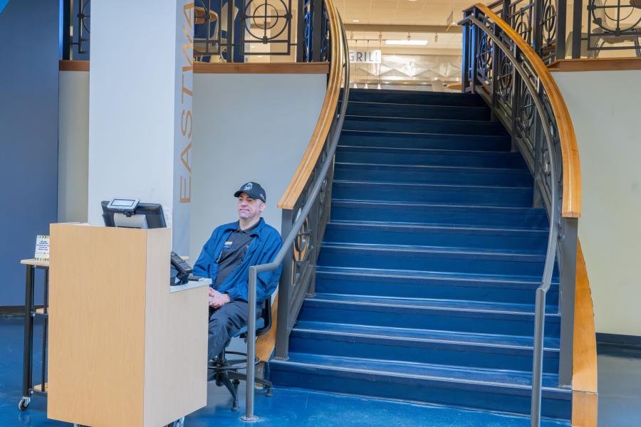 View of one of the entrances to Eastway Dining Hall, showing an attendant at a small counter where guests pay to enter, and a staircase leading up to the dining hall