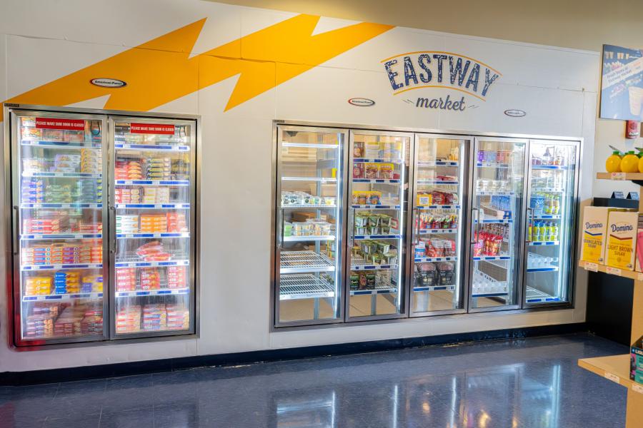 Wide view of display coolers and display freezers filled with available products at Eastway Market